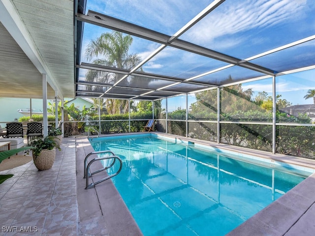 view of pool featuring glass enclosure and a patio