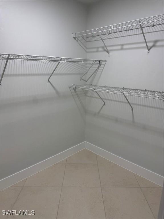 walk in closet with tile patterned floors