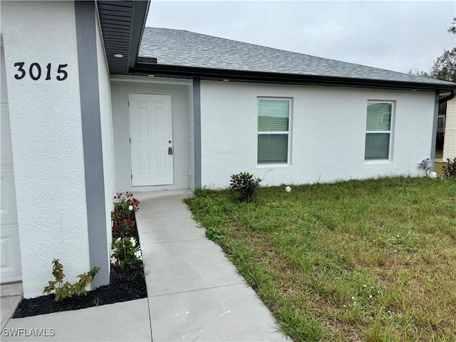 view of exterior entry with a lawn