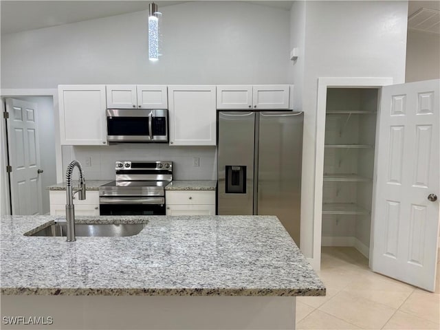 kitchen with sink, white cabinetry, light stone countertops, and stainless steel appliances