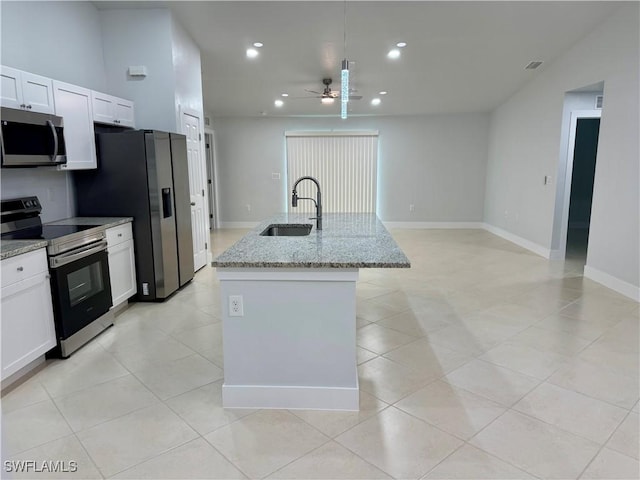 kitchen featuring sink, white cabinets, appliances with stainless steel finishes, and a kitchen island with sink