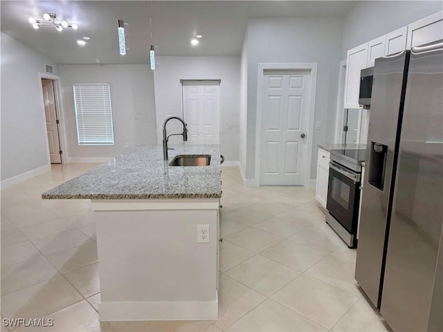 kitchen with decorative light fixtures, white cabinetry, light stone counters, a center island with sink, and stainless steel appliances