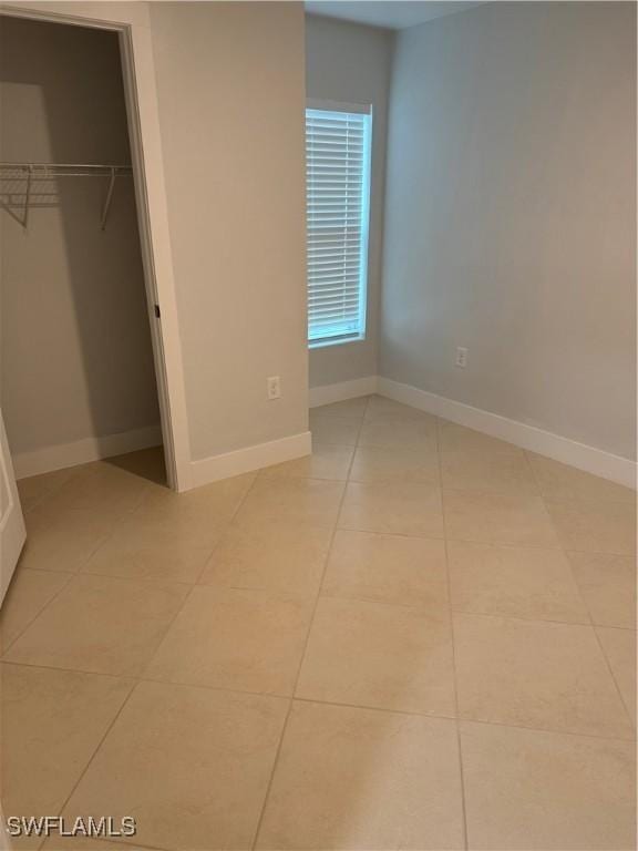 unfurnished bedroom with light tile patterned floors and a closet