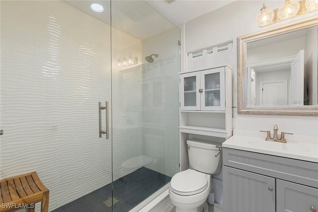 bathroom featuring toilet, an enclosed shower, and vanity