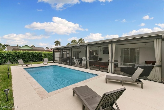 view of swimming pool with a patio area and a sunroom