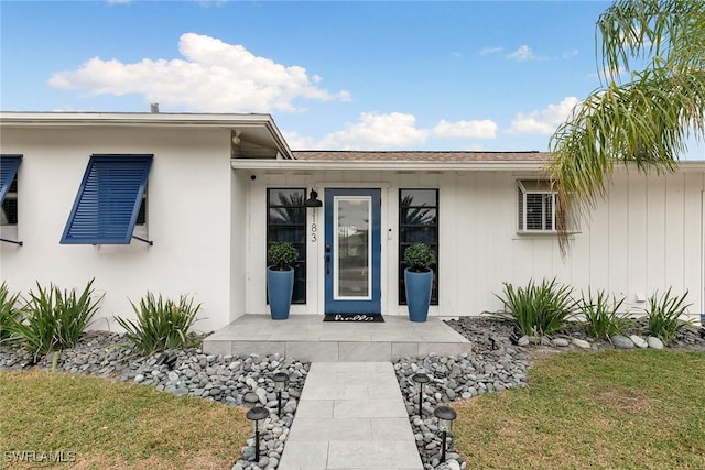 entrance to property with a patio and a lawn