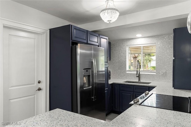 kitchen with sink, stainless steel refrigerator with ice dispenser, stove, and light stone countertops