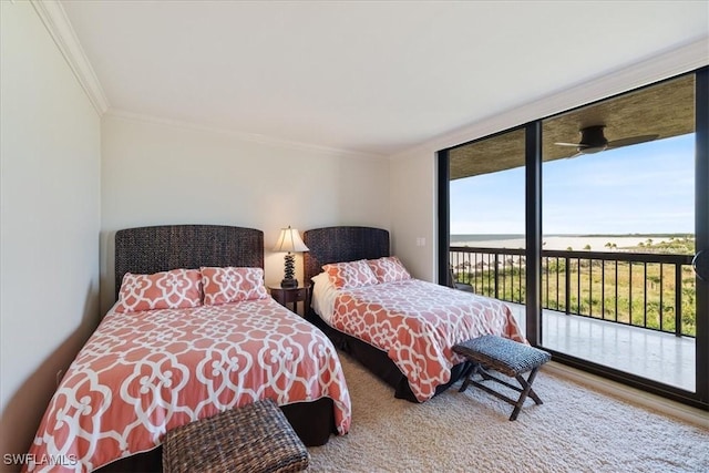 bedroom featuring a wall of windows, ornamental molding, and access to outside