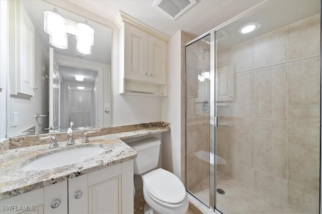 bathroom with toilet, walk in shower, and vanity