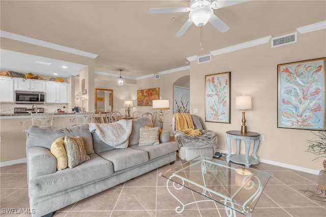 living room featuring crown molding, ceiling fan, and light tile patterned flooring