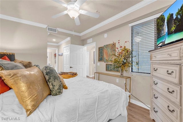 bedroom with ensuite bathroom, light hardwood / wood-style flooring, ornamental molding, ceiling fan, and a closet