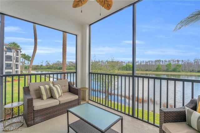 sunroom / solarium with ceiling fan and a water view