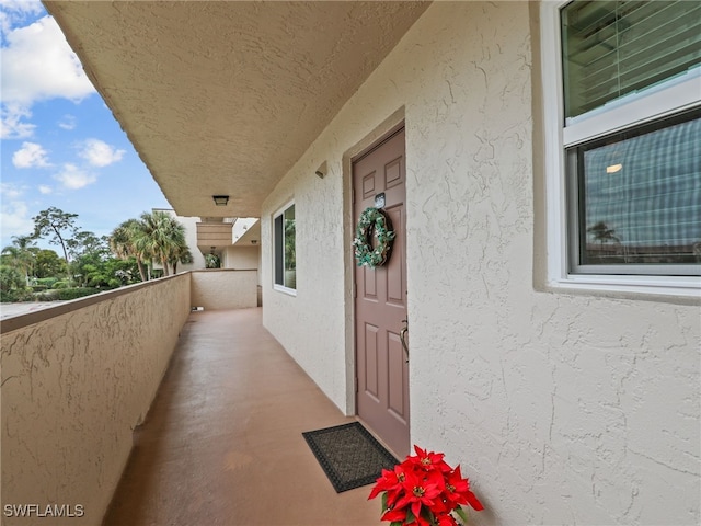 view of exterior entry with a balcony