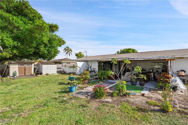 back of house with a storage shed, a lawn, and a patio