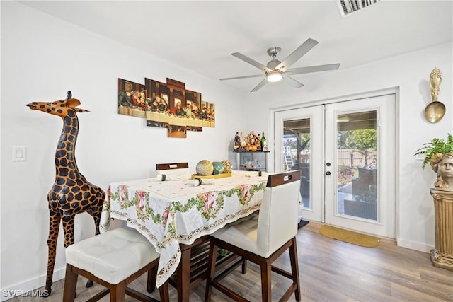 dining space featuring ceiling fan, wood-type flooring, and french doors