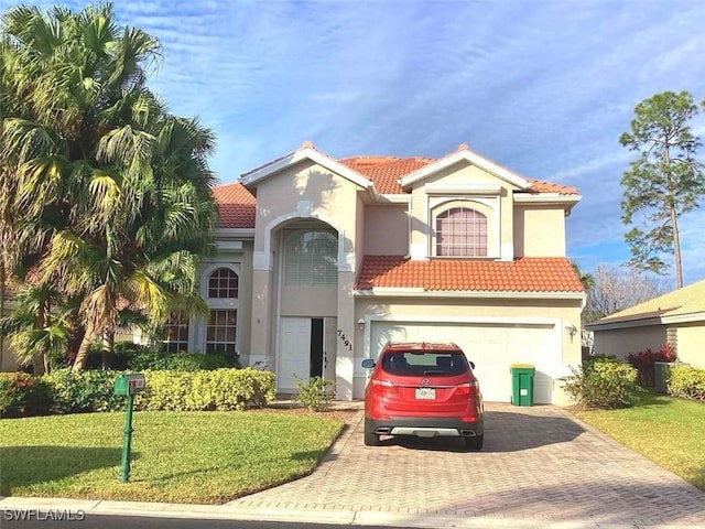 mediterranean / spanish-style house featuring a garage and a front lawn