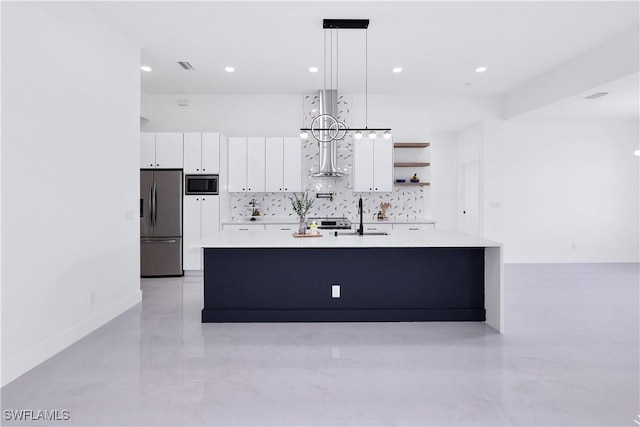 kitchen with a center island with sink, pendant lighting, sink, white cabinetry, and appliances with stainless steel finishes