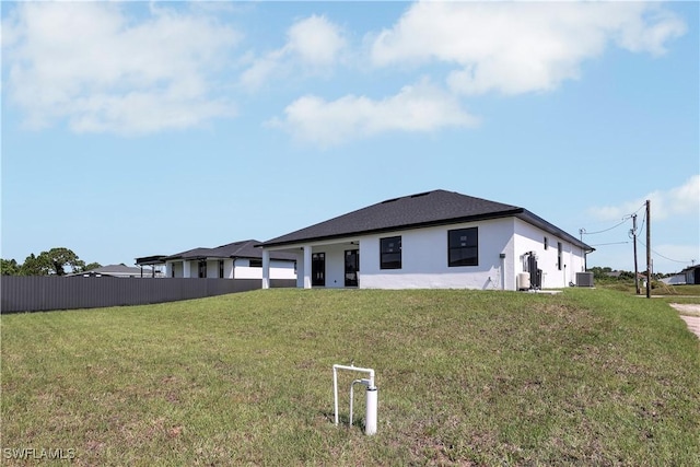 view of front of home with central AC unit and a front lawn