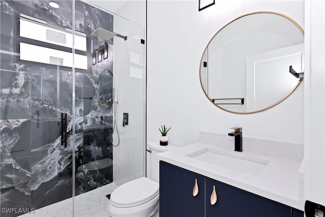 bathroom featuring toilet, vanity, and a shower with shower door