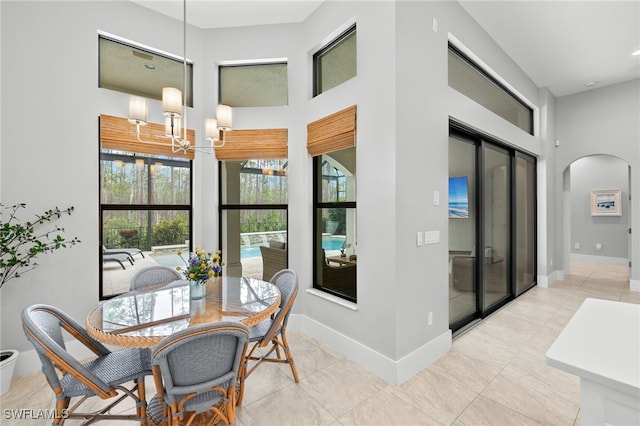 dining area with an inviting chandelier and a towering ceiling