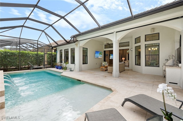 view of swimming pool featuring pool water feature, area for grilling, a lanai, ceiling fan, and a patio