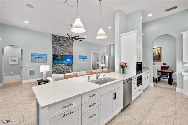 kitchen with sink, stainless steel dishwasher, hanging light fixtures, and white cabinets