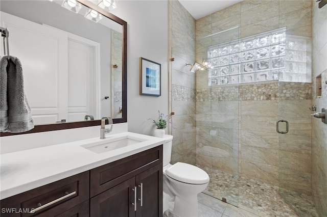 bathroom with vanity, a shower with shower door, and toilet