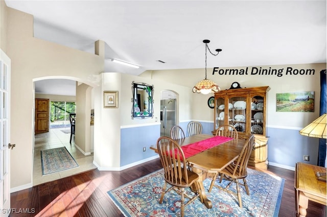 dining area featuring dark wood-type flooring and lofted ceiling