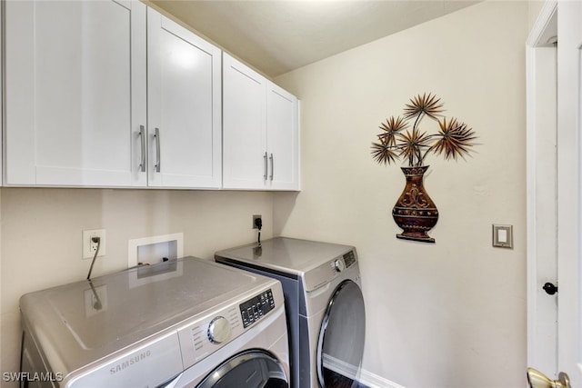 laundry room featuring cabinets and washer and dryer