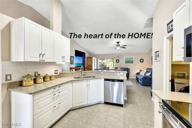 kitchen with kitchen peninsula, appliances with stainless steel finishes, sink, white cabinets, and decorative backsplash