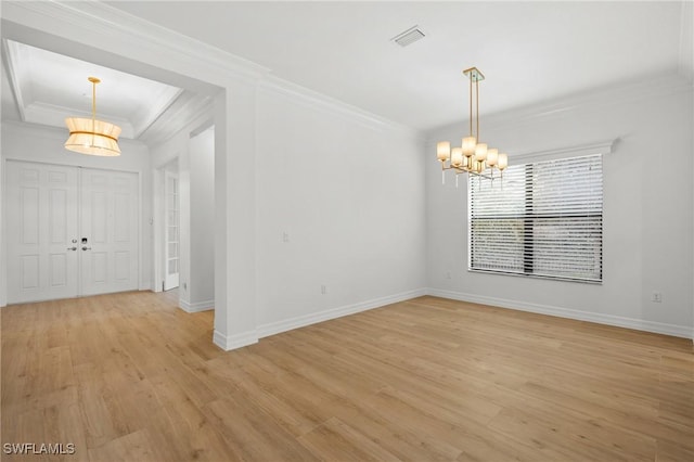 empty room with light wood-type flooring, crown molding, and an inviting chandelier