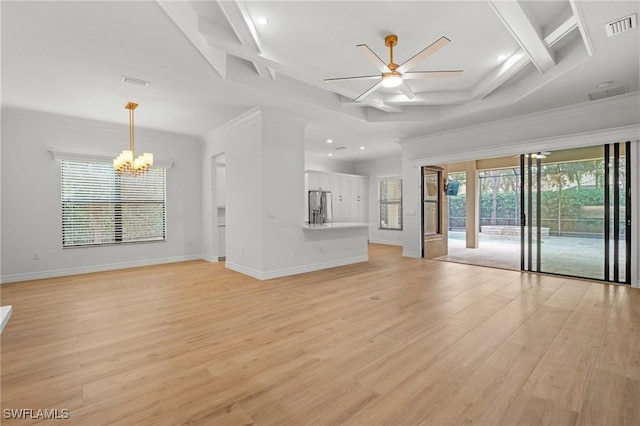 unfurnished living room with ceiling fan with notable chandelier, light wood-type flooring, visible vents, and baseboards