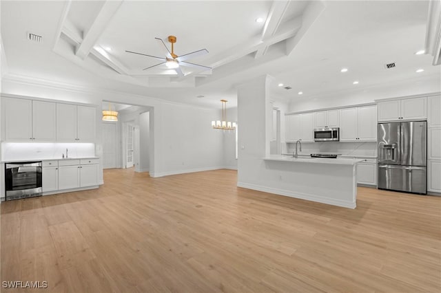 kitchen with stainless steel appliances, wine cooler, open floor plan, and light wood-style floors