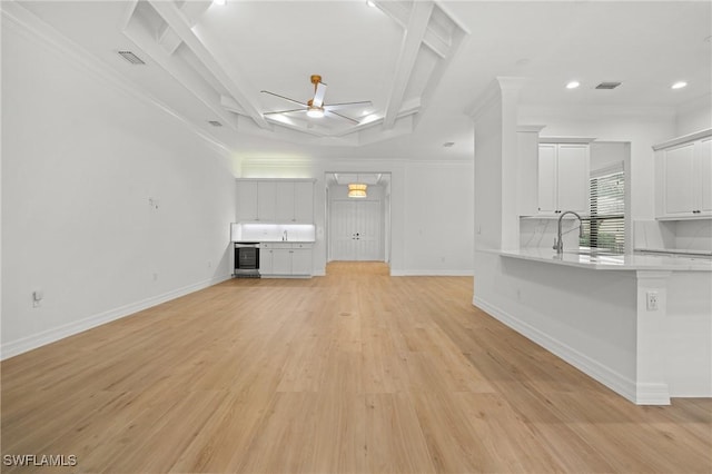 unfurnished living room with baseboards, light wood-style flooring, ceiling fan, a sink, and recessed lighting