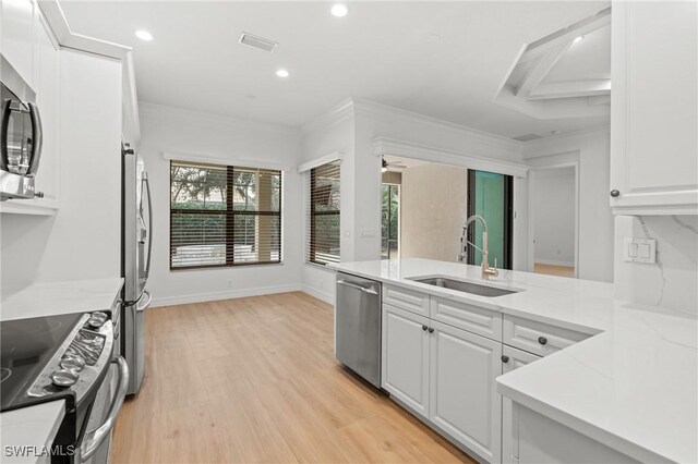 kitchen featuring light hardwood / wood-style floors, sink, white cabinets, stainless steel appliances, and light stone counters