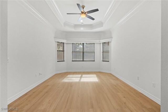 unfurnished room featuring ceiling fan, ornamental molding, light hardwood / wood-style floors, and a tray ceiling