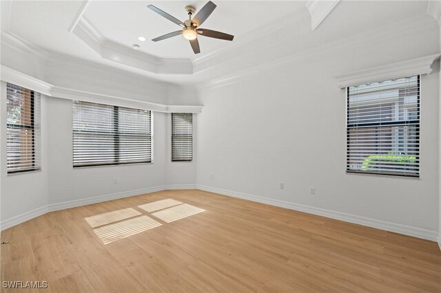 unfurnished room featuring ceiling fan, light hardwood / wood-style flooring, a raised ceiling, and crown molding