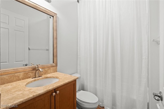 full bath featuring toilet, a shower with shower curtain, and vanity