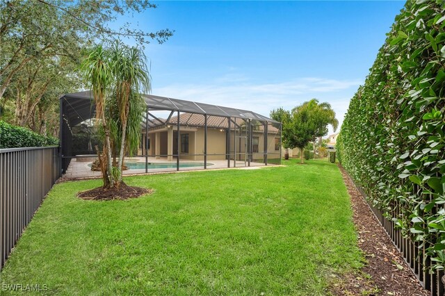 view of yard with a lanai and a swimming pool