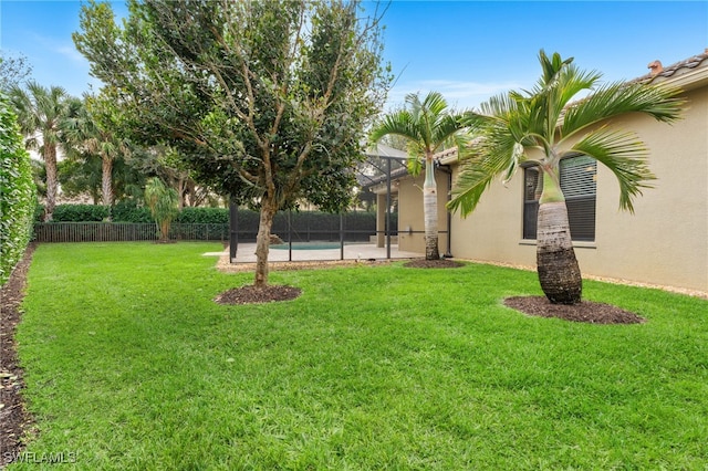 view of yard featuring a fenced in pool and glass enclosure