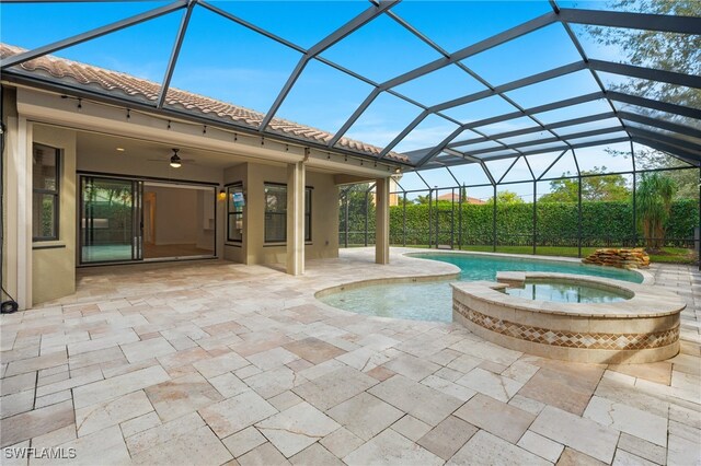 view of swimming pool with an in ground hot tub, a lanai, ceiling fan, and a patio