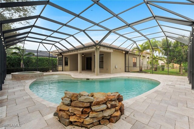 view of pool featuring a patio, an in ground hot tub, glass enclosure, and ceiling fan