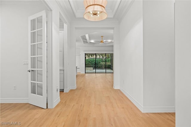 hallway with a chandelier, ornamental molding, light wood-style flooring, and baseboards