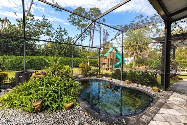 view of swimming pool featuring a lanai and a playground