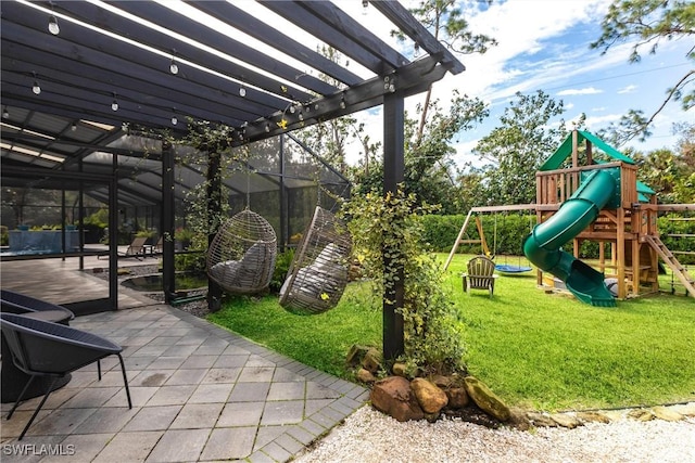 view of play area with a pergola, a lawn, and a patio area