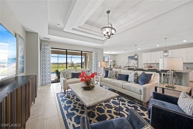 tiled living room featuring a raised ceiling and an inviting chandelier