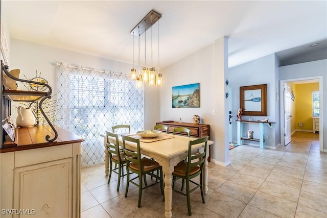 tiled dining room featuring a wealth of natural light and an inviting chandelier