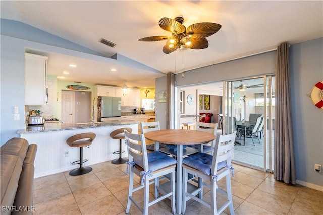 dining area with ceiling fan, lofted ceiling, and light tile patterned flooring