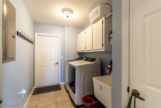 washroom with light tile patterned floors, washing machine and dryer, cabinets, electric panel, and sink