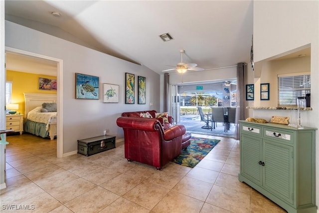 living room with ceiling fan, light tile patterned floors, and vaulted ceiling